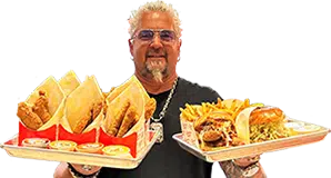 Guy Fieri holding two trays of Chicken Guy! food