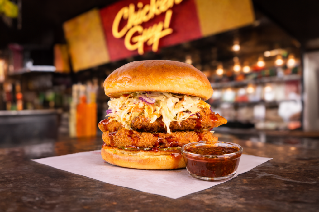 Crispy fried chicken sandwich topped with coleslaw and sauce on a toasted bun.